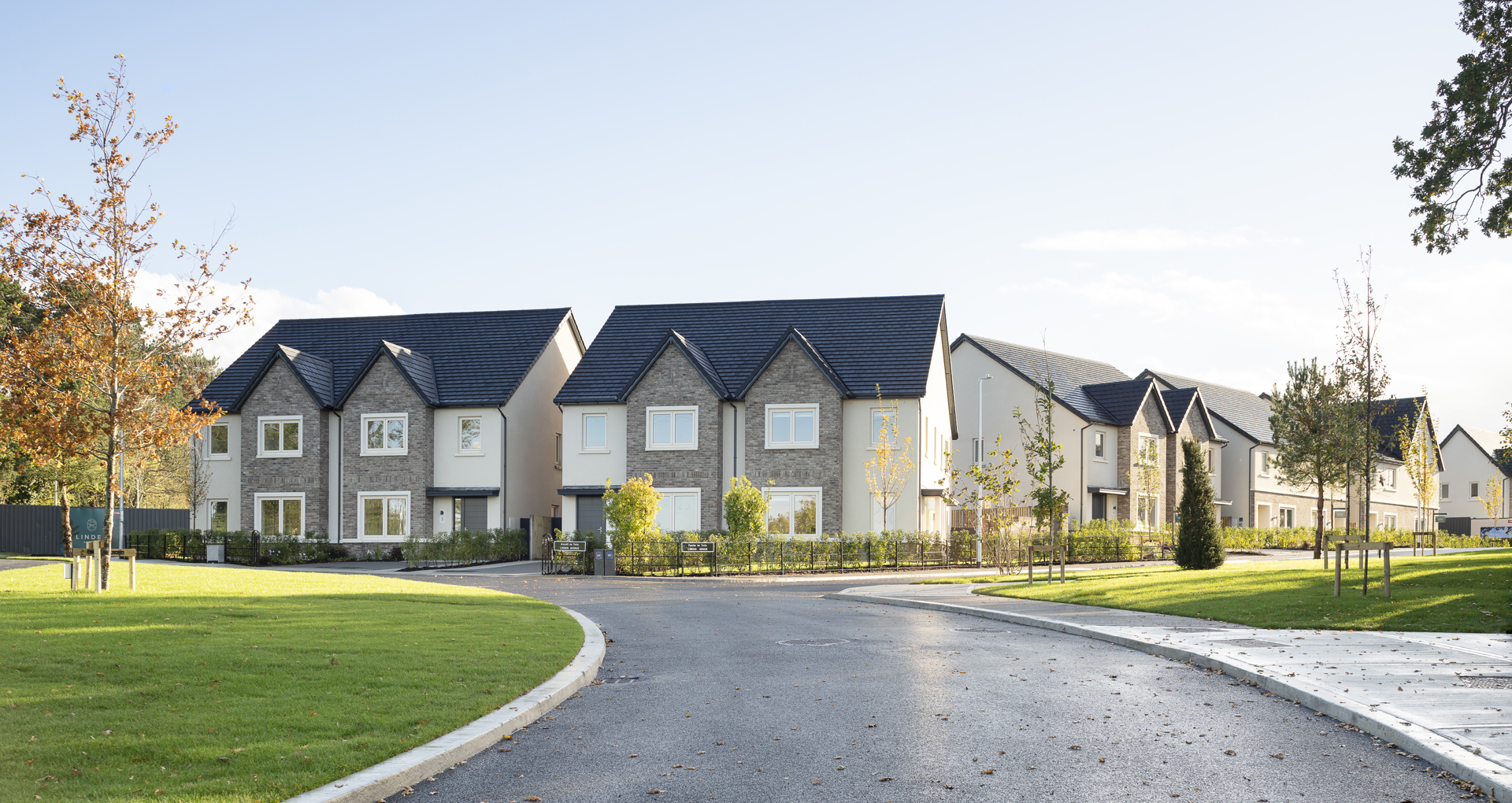Street of newly built homes at Linden Demesne with a landscaped green