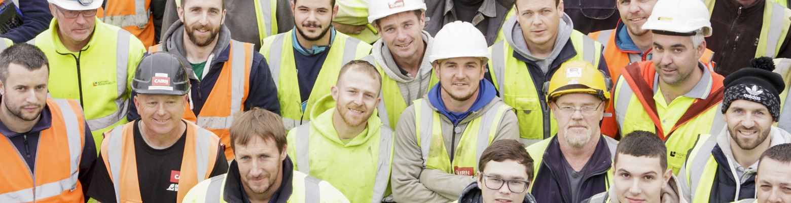 Large group of Cairn site workers in hi-vis and hard hats gathered together on site
