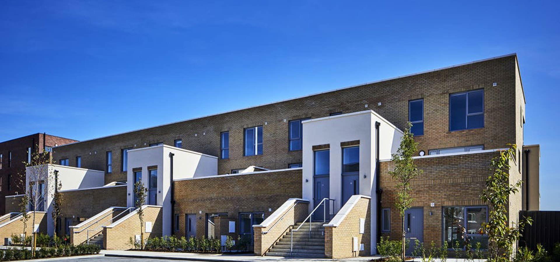 Terrace of newly completed duplex homes with front steps and railings