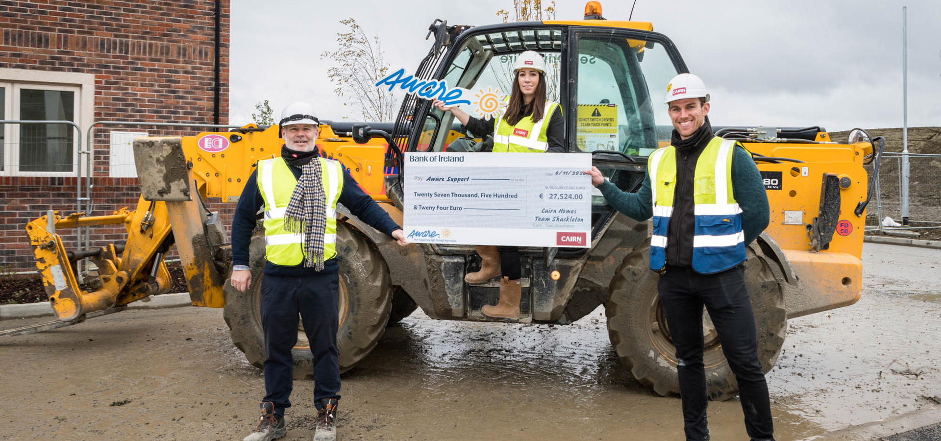 Cairn's Shackleton Park team with a large fundraising cheque for Aware, in front of a telehandler