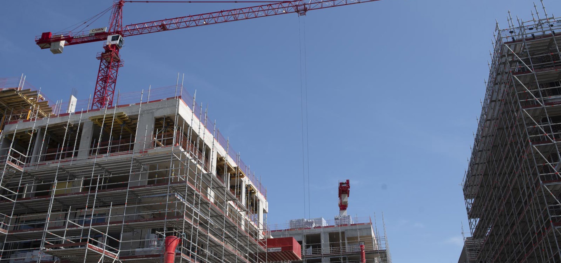 Apartment building under construction, with scaffolding and a tower crane